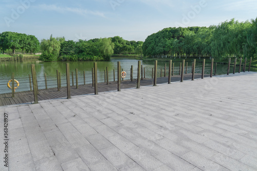 The brick walkway ground by a lake.