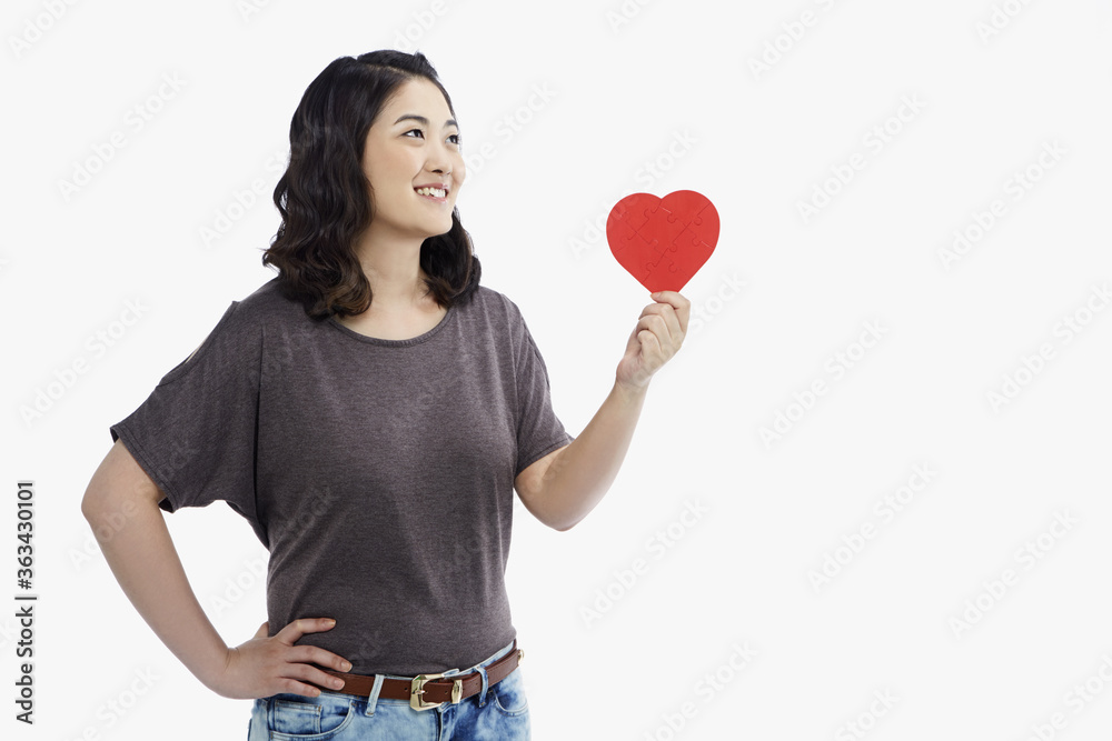 Cheerful woman holding up a red heart shape Cheerful woman holding up a red heart shape