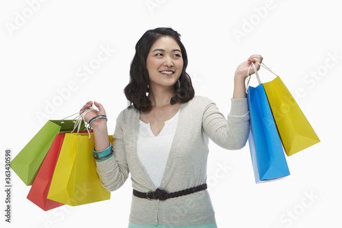 Happy woman holding up colorful paper bags