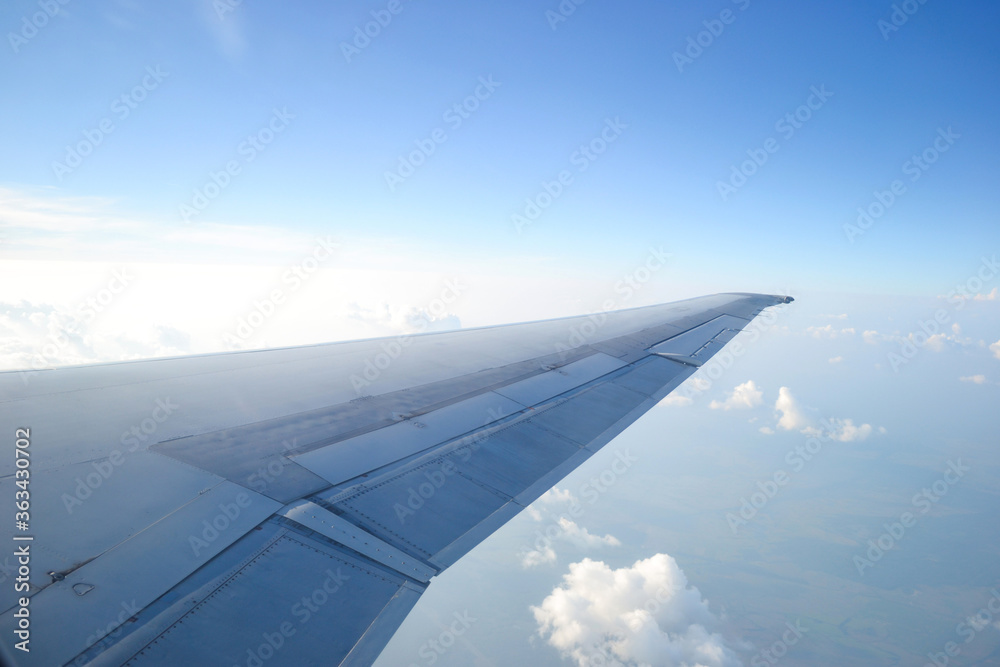 view from airplane window, wing of the plane against the sky.