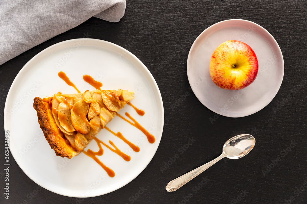 Slice of French apple tart, an open faced apple pie, aside a Gala apple
