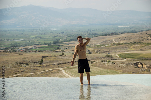 Young man walking in the natural pool. Pamukkale, beautiful view. © Ihor