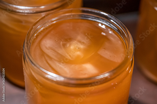 Golden yellow honey in glass jar on wooden board Closeup Copy space comp frame empty textspace