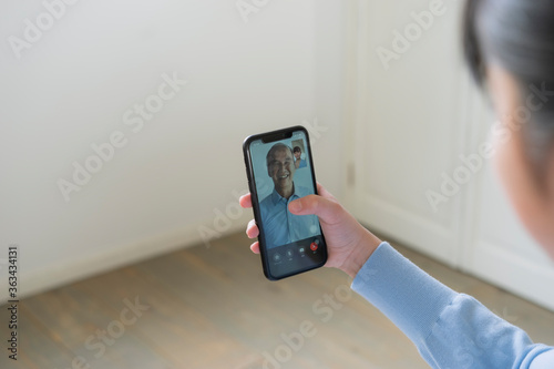 スマートフォンで祖父とビデオ通話をする女の子