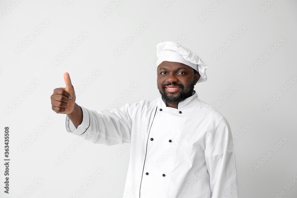 Male African-American chef showing thumb-up on white background Male African-American chef showing thumb-up on white background
