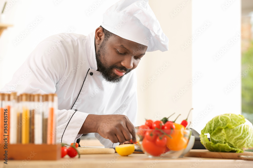 Male African-American chef cooking in kitchen Male African-American chef cooking in kitchen
