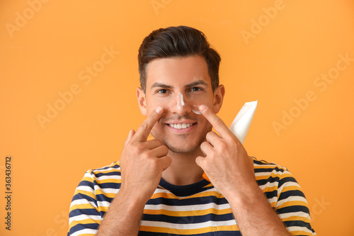 Young man applying sunscree...