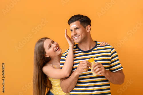 Young couple applying sunsc...