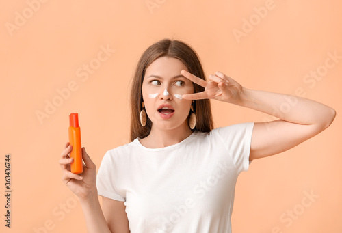 Young woman applying sunscr...