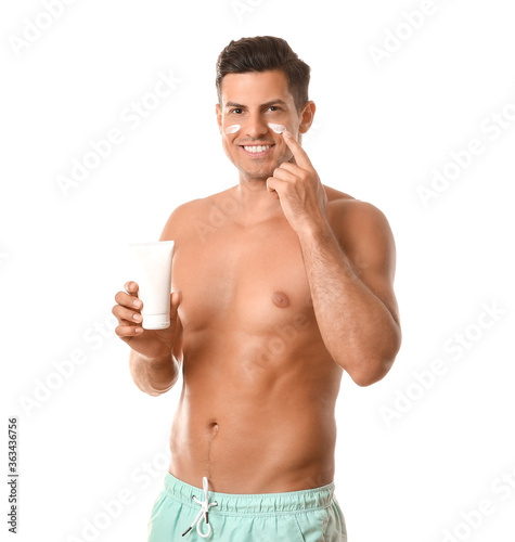 Young man applying sunscree...