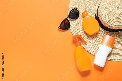 Beach accessories with sunscreen cream on color background photo