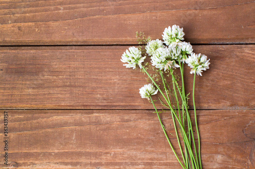 Wildflowers on a wooden background. Bouquet of clover. Place for text.