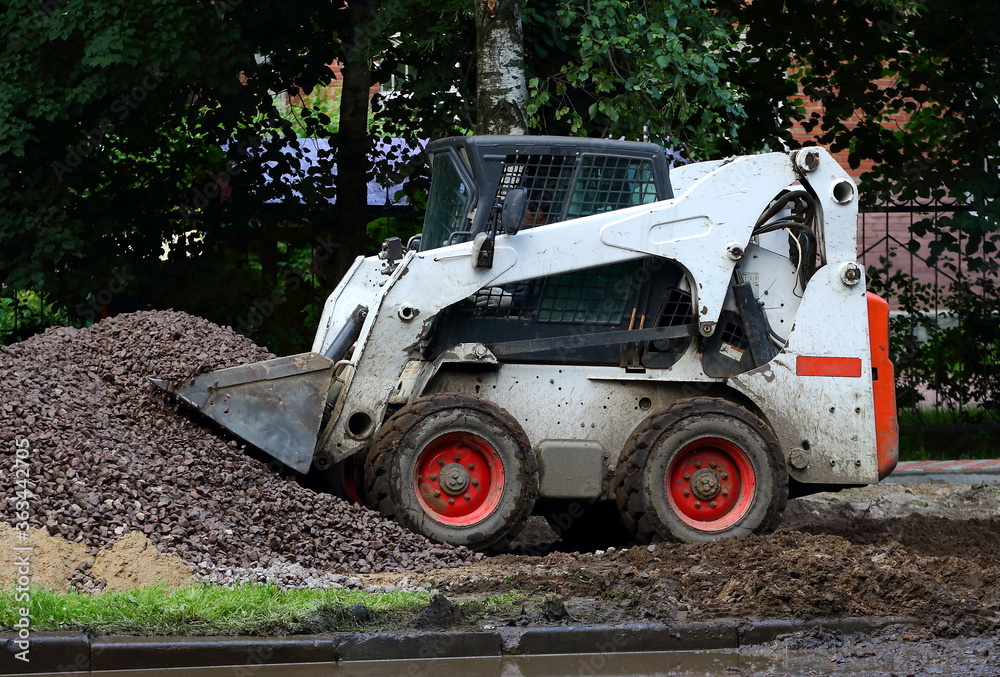 White small tractor working on the loading of crushed stone White small tractor working on the loading of crushed stone