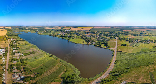 Blue pond on the Zelenchuk II river near the village of Staroarmyanskoye (Krasnodar Territory, South of Russia) surrounded by wheat fields - aerial drone small panorama on a sunny day