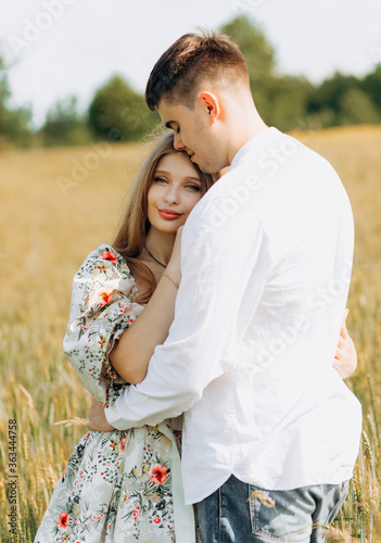 Beautiful loving couple standing in the field, summer mood