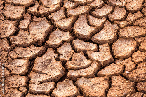 Horizontal background of the desiccation cracks in dry earth. A drought or drouth is a natural disaster of below-average precipitation in a given region. photo