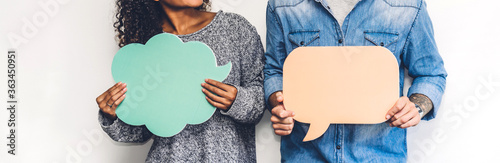 Two friends holding a speech bubble icon together