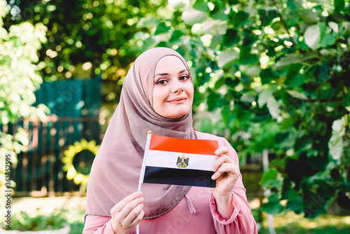 Foto Muslim woman in hijab holds flag of Egypt