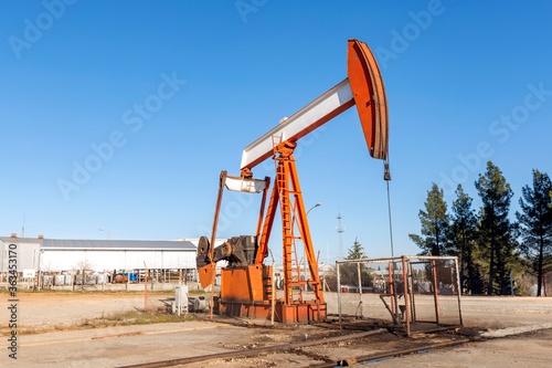 Close up view of the pump jack. A pumpjack is the overground drive for a reciprocating piston pump in an oil well. Modern pumpjacks are powered by a prime mover.