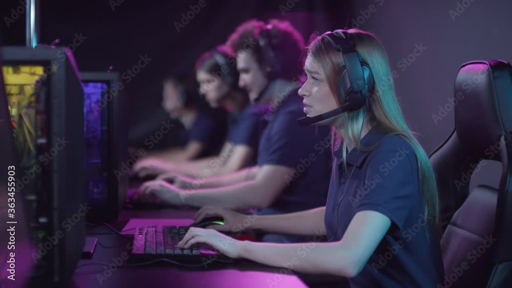 Young woman taking part in cybersport competition losing round in video game, taking off headphones and getting upset Young woman taking part in cybersport competition losing round in video game, taking off headphones and getting upset