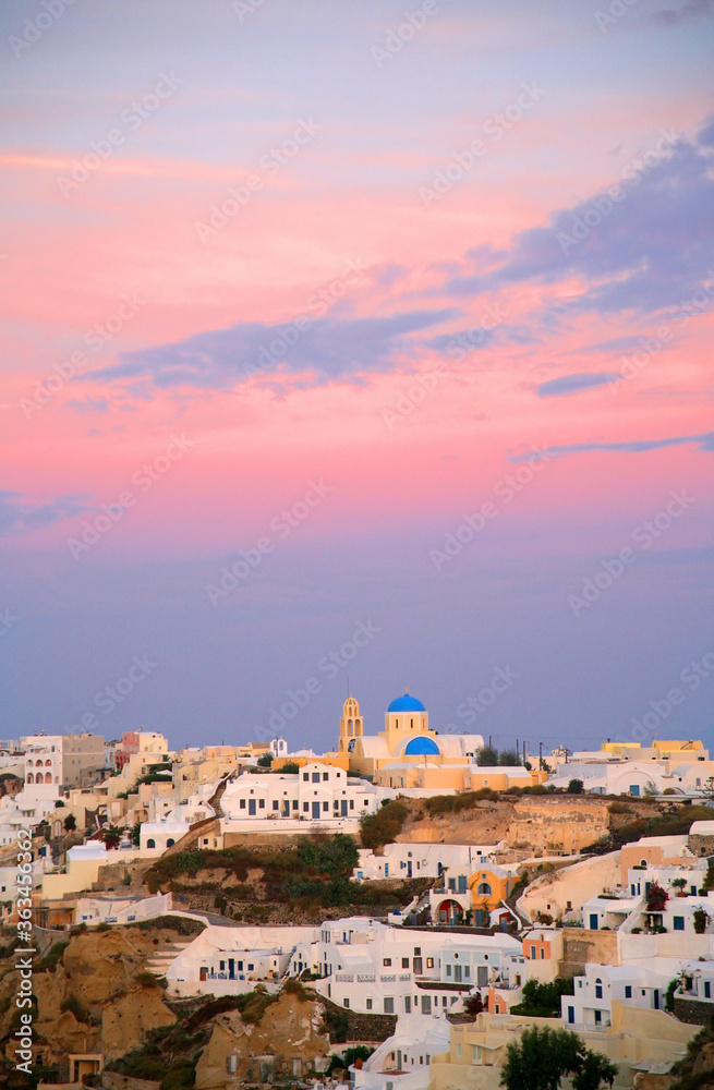 Fototapeta premium Beautiful village of Oia on the island of Santorini, Greece, white buildings, blue sky, terraced cliffs