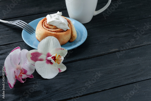 synabon on a wooden table with a cup of coffee and orchids