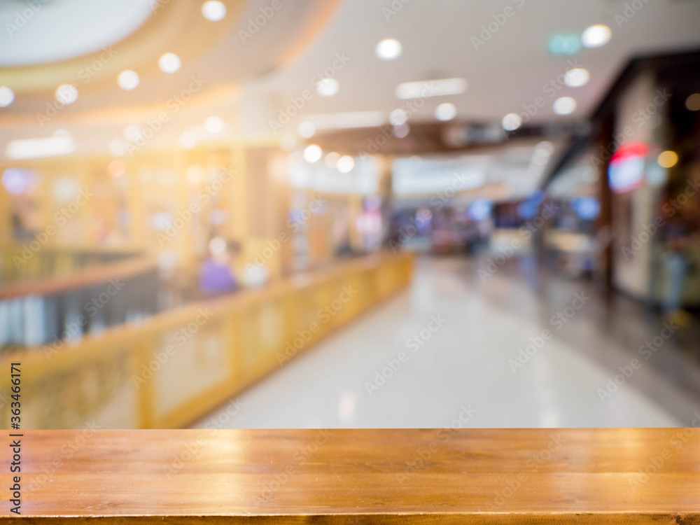 Empty wooden table in front of abstract blurred background of the mall . can be used for display or montage your products.Mock up for display of product