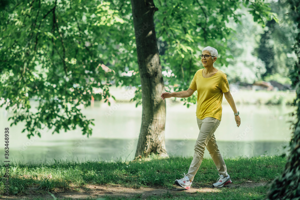 Mature Woman Enjoying Walking Exercise by the Lake Mature Woman Enjoying Walking Exercise by the Lake