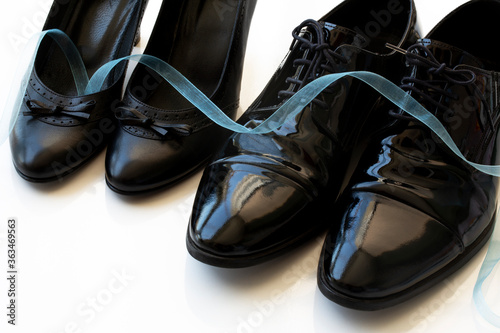 Black man and woman patent leather shoes on white background. Copy space for text. Wedding. Divorce. Honeymoon.