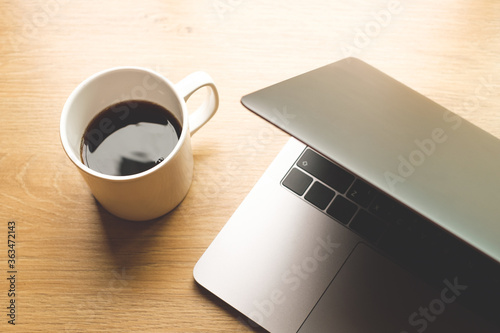 Black coffee with coffee bean and laptop computer on wooden table copy space photo