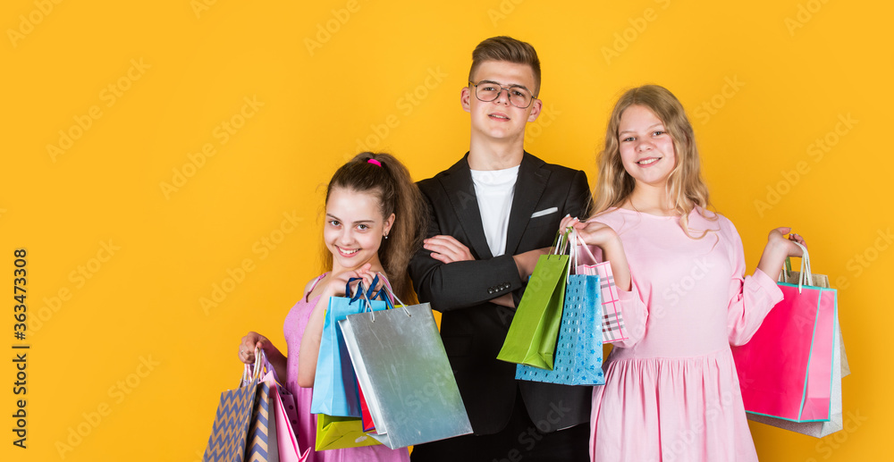 group of children go shopping. black friday concept. kids on cyber monday. big sale. teen girls and boy hold paper bag. buy gifts for holiday. shopaholic kids with purchase packages