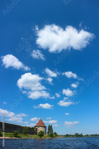 Summer view to Shlisselburg (Oreshek) fortress on the island of Ladoga lake under beautiful bright blue sky with clouds