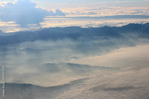 View of earth with the mountain and sea during sunrise from airplane