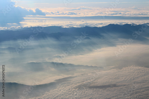 View of earth with the mountain and sea during sunrise from airplane