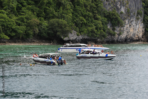 Touristboats with tourists, near eroded overgrown limestone rocks in Phang Nga Bay, Ao Phang Nga Marine National Park, Thailand, photo