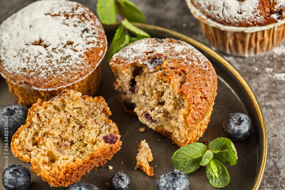 Several fragrant muffins with blueberries are on the table, next to blueberries and mint. Several fragrant muffins with blueberries are on the table, next to blueberries and mint.