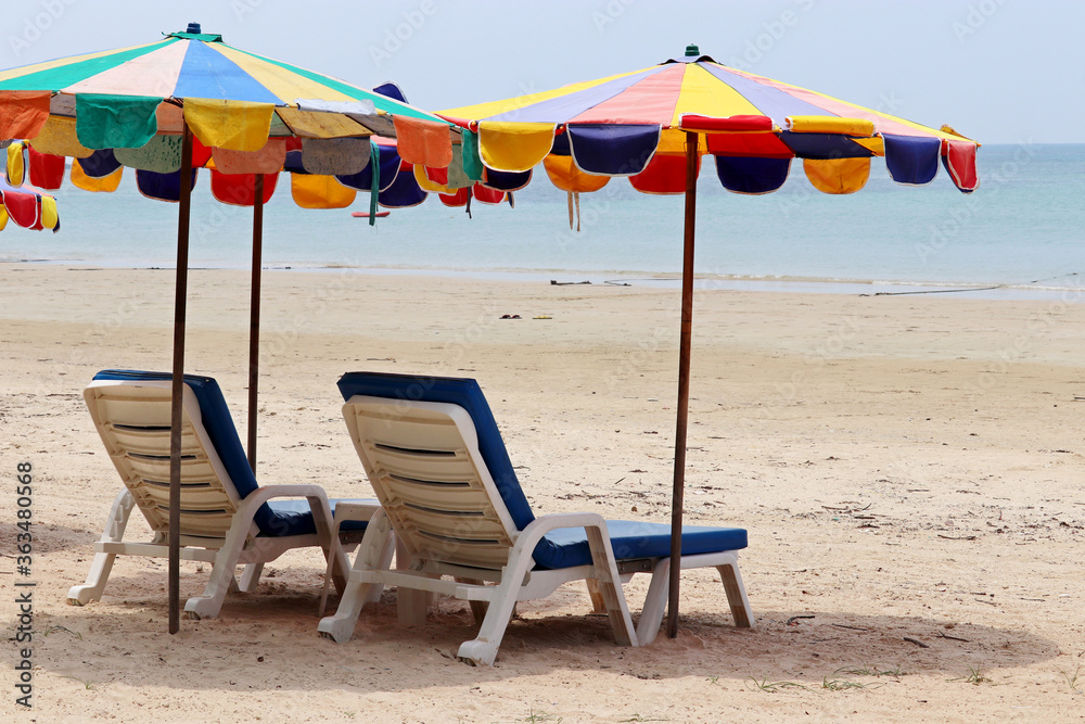 Sea sandy beach with empty sunbeds and umbrellas. Vacation on summer resort during coronavirus pandemic