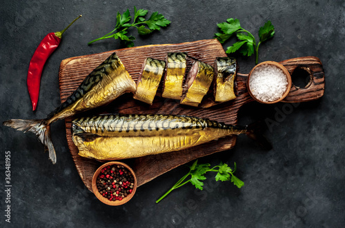  Smoked mackerel on a cutting board on a stone background