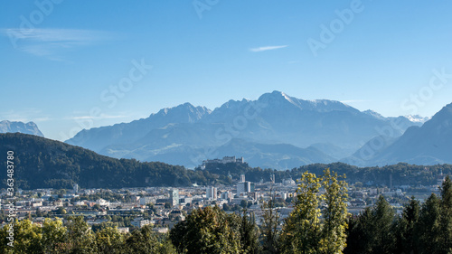 Blick auf Salzburg Stadt, die Festung Hohensalzburg und die umliegenden Berge aus größerer Entfernung