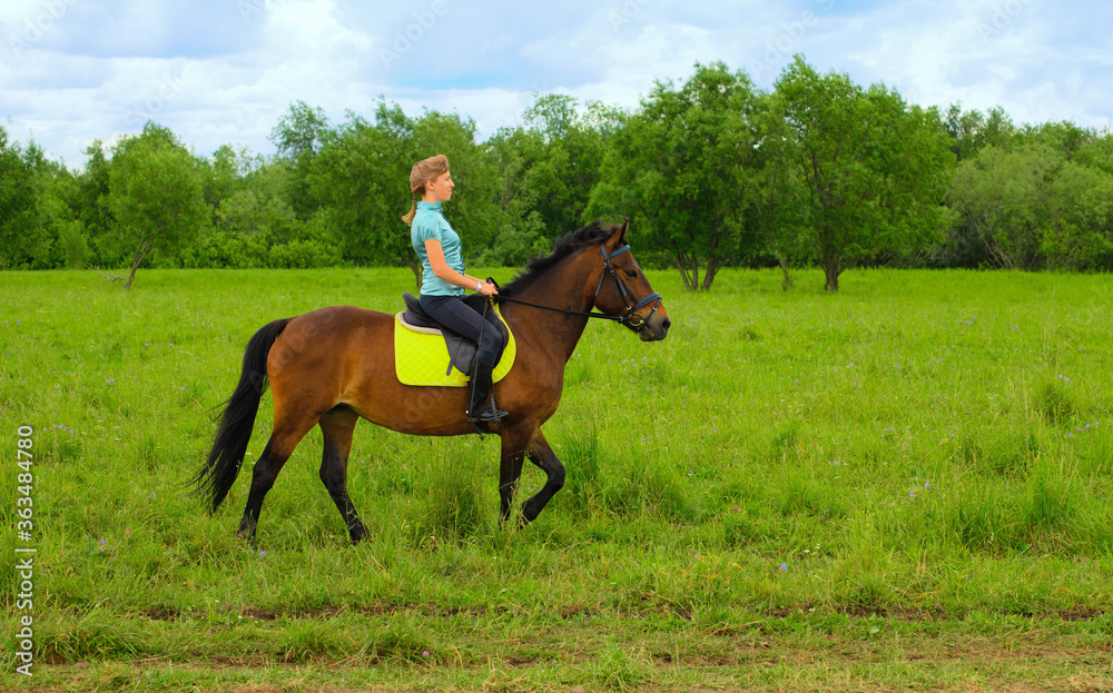 One Caucasian horsewoman is riding in the countryside. One Caucasian horsewoman is riding in the countryside.