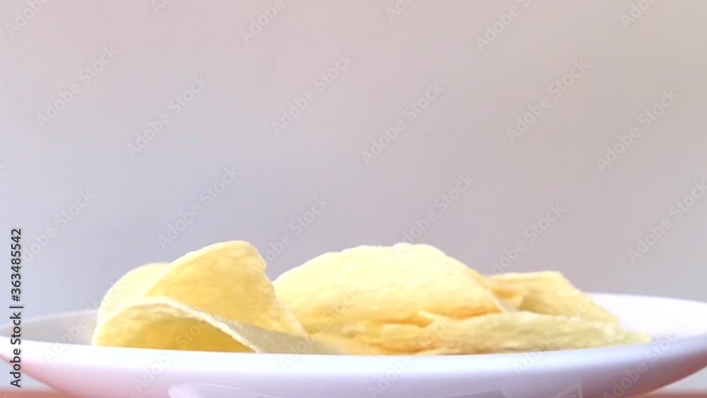 Hand picked round crispy potato chips in a white swirling dish Hand picked round crispy potato chips in a white swirling dish