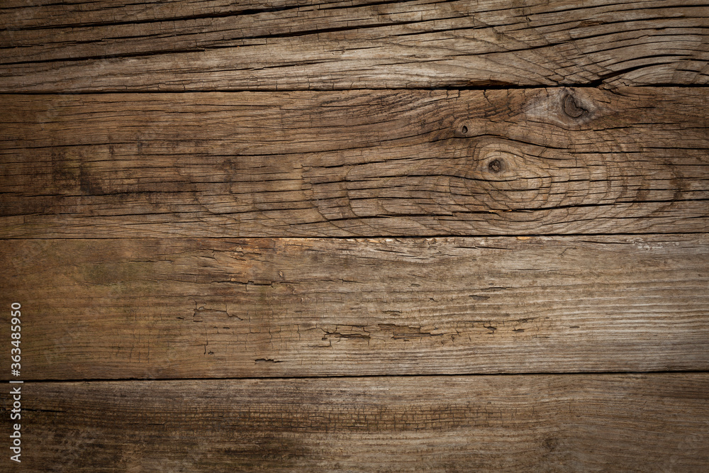 Old wooden table with cracks and scratches, aged rustic background.