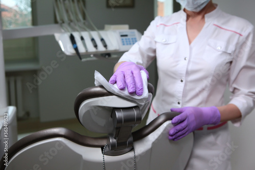 A nurse disinfects work surfaces in the dentist's office. Unrecognizable photo.The concept of health. Copy of the space. © Alla