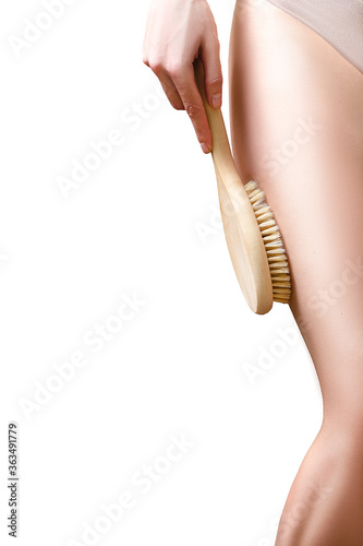 woman doing a massage against cellulite with body brush white background closeup