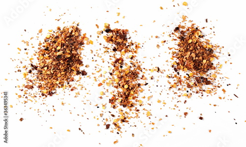 Spicy chili pepper flakes, crushed, milled dry red paprika pile isolated on white background, top view