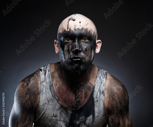 Bald mad man with black goo in the mouth photo