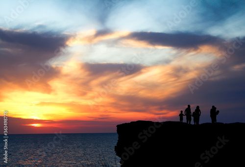 a family sightseeing dawn on a cliff / silhouette