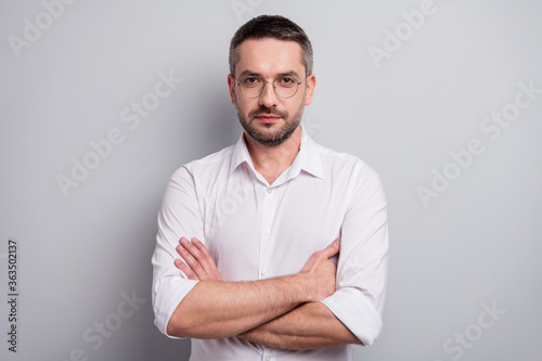 Close-up portrait of his he nice attractive serious masculine mature man skilled experienced specialist shark wearing specs folded arms isolated over light gray pastel color background © deagreez