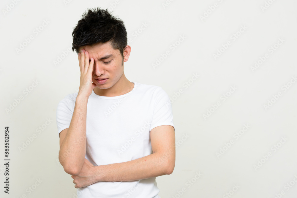 Portrait of stressed young Asian man thinking and looking down