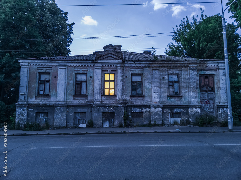 Exterior of old, low-rise, European house of the end of the 19th century in dusk.